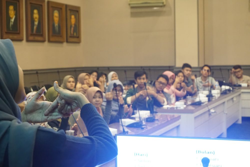 Seorang difabel Tuli memperagakan praktik berbahasa isyarat di pelatihan Bahasa Isyarat Dasar pada volunteer.